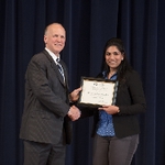 Doctor Potteiger posing for photo with an award recipient in a black blazer and a blue patterned top